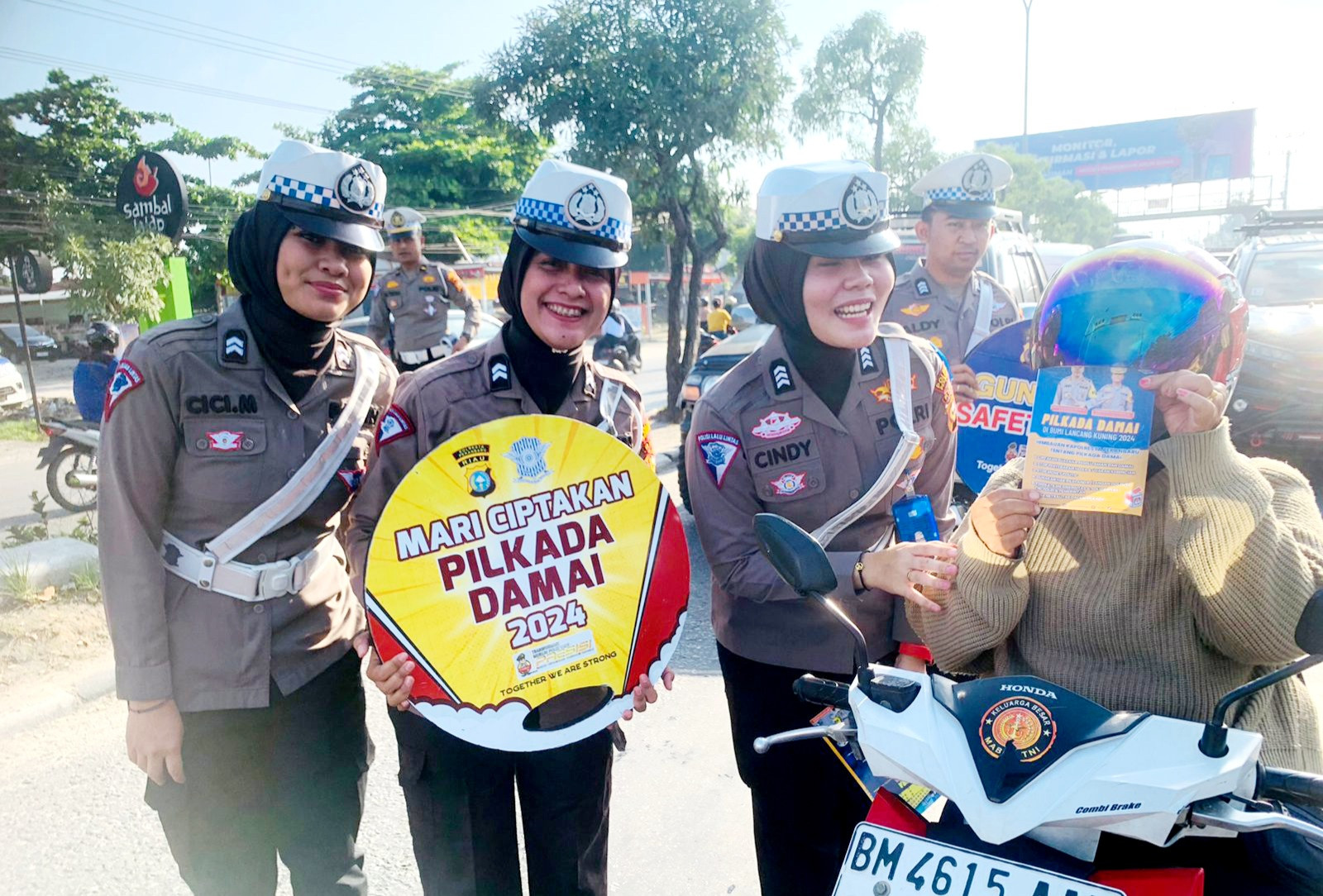Bawah Papan Gimmick Pesan Pilkada Damai, Polwan Cantik Gencar Sosialisasi di Jalan Raya